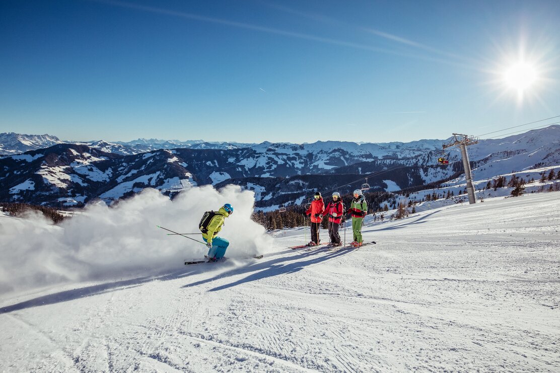 Eine Freundesgruppe steht am Rand der Skipiste und einer der Vieren, staubt die anderen drei mit Schnee ein | © Ski Juwel Alpbachtal Wildschönau 