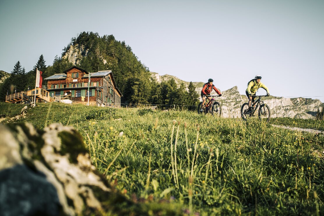 Nach der Einkehr fährt ein Paar mit den E-Bikes von der Bayreutherhütte hinunter in Richtung Alpbachtal  | © WOM Medien | Stefan Schopf