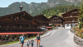 Eine Familie spaziert Hand in Hand durch das Dorfzentrum in Alpbach  | © Alpbachtal Tourismus | Matthäus Gartner 