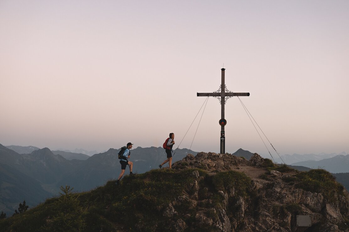 Eine Frau und ein Mann wandern zum Gipfelkreuz des Berges Gratlspitze  | © Alpbachtal Tourismus | Mathäus Gartner