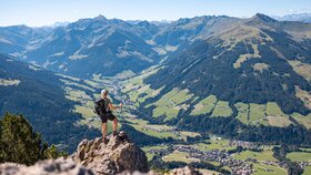 Eine Frau steht auf einem Fels auf dem Gipfel Gratlspitze und betrachtet die schöne Aussicht auf das Alpbachtal  | © Alpbachtal Tourismus | shootandstyle 