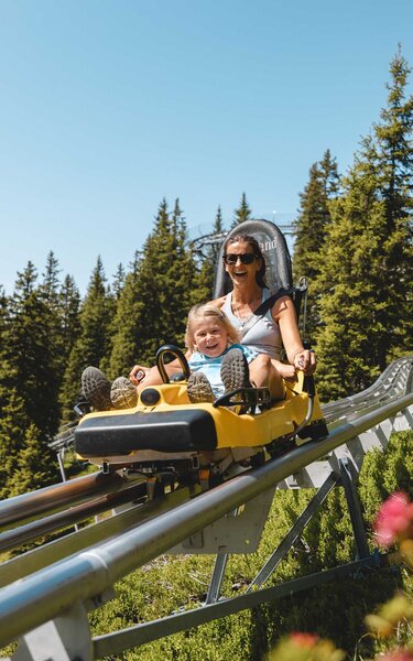 Mutter fährt gemeinsam mit ihrem Sohn eine Runde mit dem Alpine Coaster Lauser Sauser in Alpbach  | © Alpbachtal Tourismus | Mathäus Gartner 