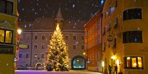 Die Stadt Rattenberg im Winter bei Nacht, inmitten der Stadt ein wunderschöner Christbaum, bedeckt von Schnee und hell erstrahlt von der Lichterkette  | © Bernhard Berger