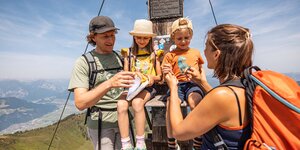 Eine Familie hat gemeinsam den Gipfel erreicht und sie freuen sich darüber sehr | © Alpbachtal Tourismus | shootandstyle 