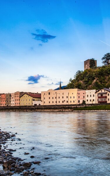 Auf diesem Bild zu sehen ist die Stadt Rattenberg mit ihren bunten Häusern, im Vordergrund der Inn, im Hintergrund der Schlossberg (eine Burgruine in Rattenberg) | © Alpbachtal Tourismus | Johann Erhard 