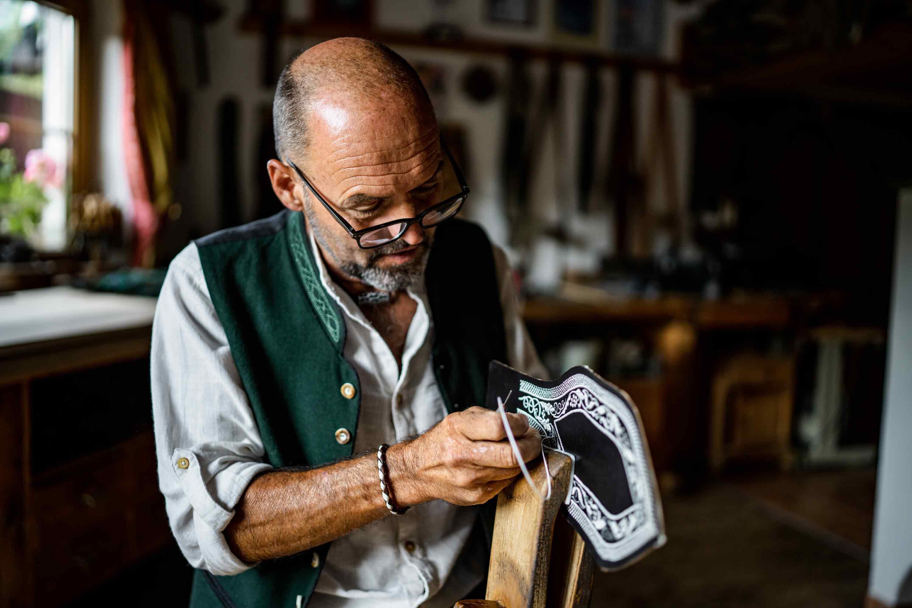 Federkielsticker Georg Leitner, aus Reith i.A., beim Ranzen sticken | © Alpbachtal Tourismus | P. Weissensteiner 